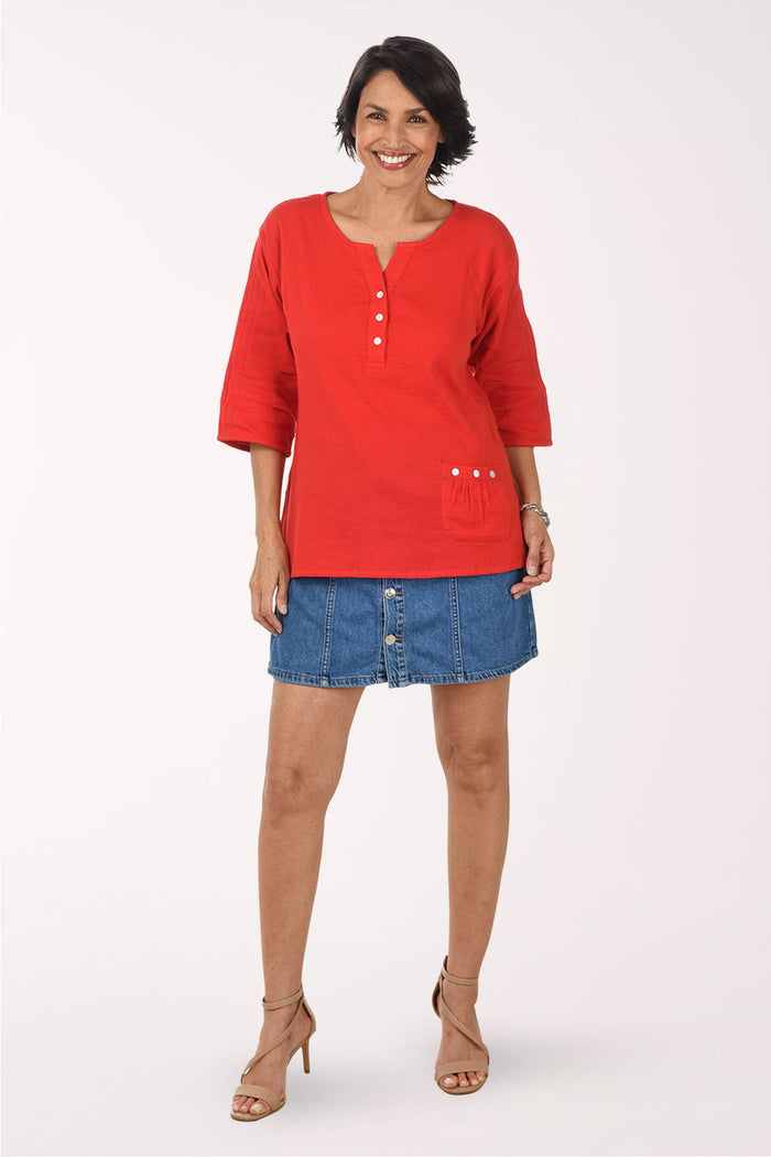 Woman wearing a red top and blue skirt on a white background